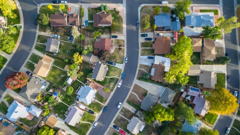 Aerial shot of a suburban neighborhood with neatly arranged homes and green lawns, highlighting the sense of security provided by home insurance