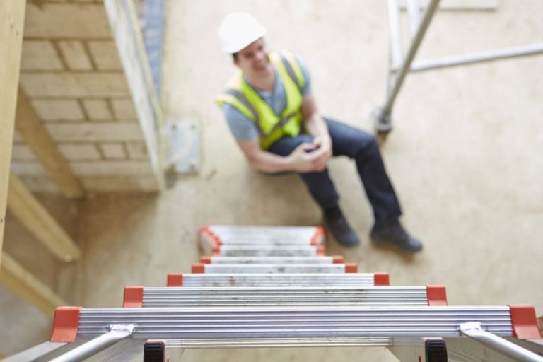 Image of a worker who has fallen from a ladder, holding their injured arm, highlighting the importance of Workers' Compensation insurance for covering accidents and injuries on the job