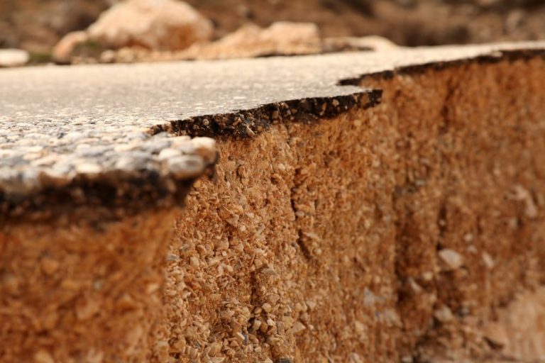 Cracked foundation and damaged home interior, highlighting the need for earthquake insurance