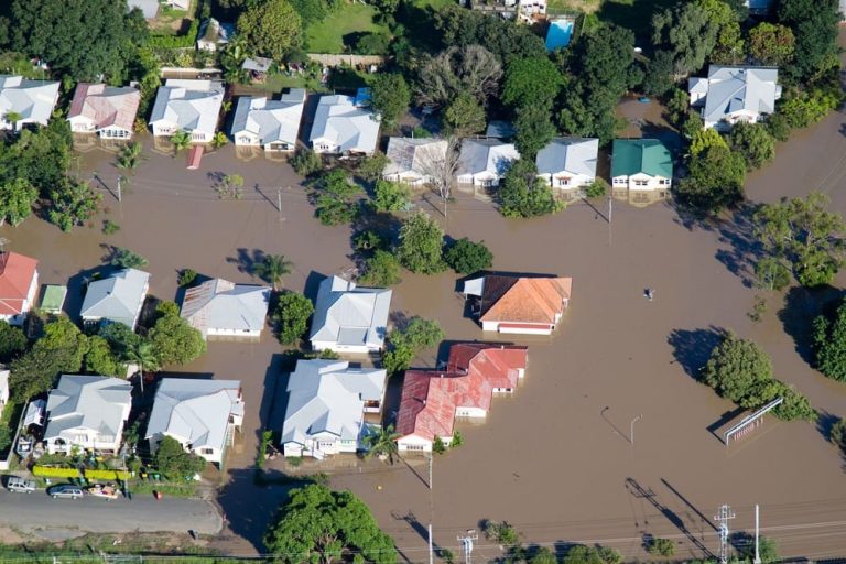 Home surrounded by floodwaters, illustrating the need for flood insurance protection