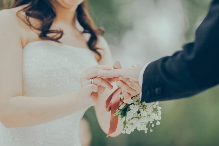 Wedding couple with a protective shield symbolizing wedding insurance coverage